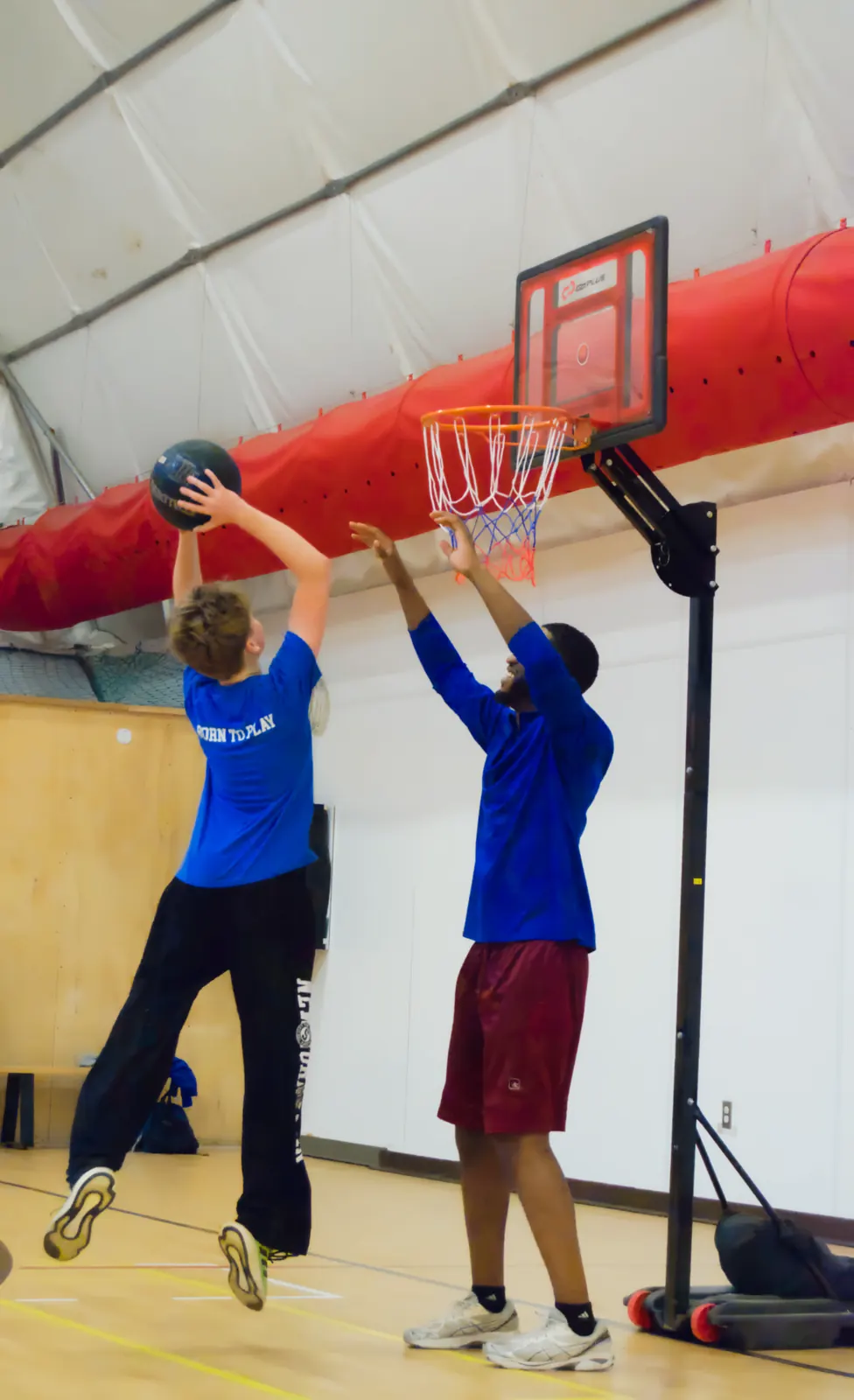 Junior Athletes participant shooting a basketball with a coach
