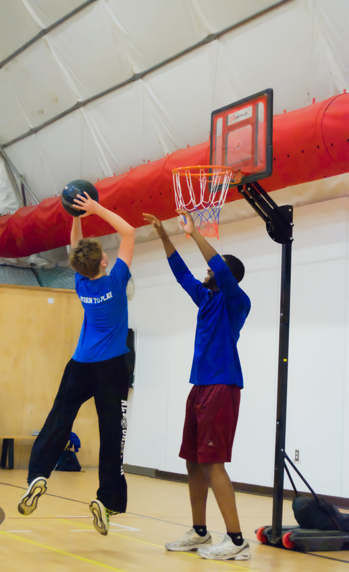 Junior Athletes participant shooting a basketball with a coach
