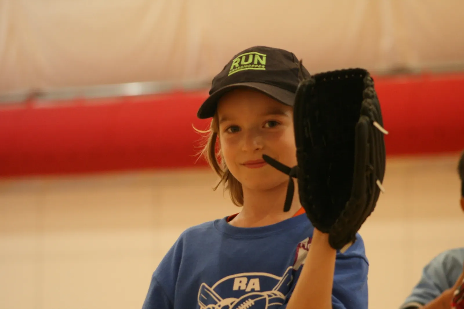 Young athlete holding a baseball glove during a Junior Athletes session